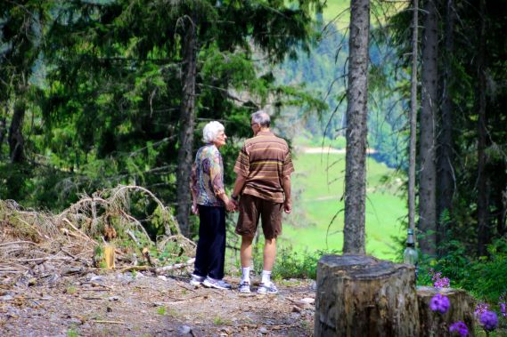 Älteres Mann-Frau-Paar geht im Wald spazieren.