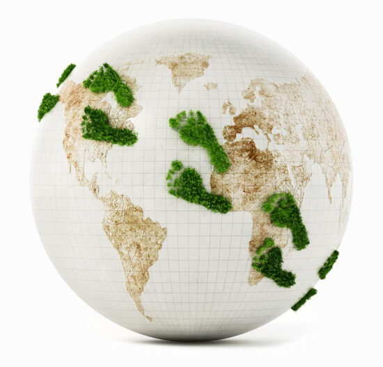 Quer über eine weiße Weltkugel gehen mit grünem Gras bewachsene Fußspuren.